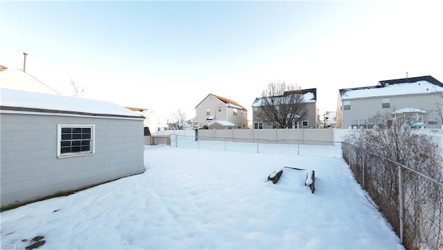 yard covered in snow featuring a fenced backyard and a residential view