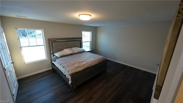 bedroom featuring dark wood-style floors, visible vents, and baseboards