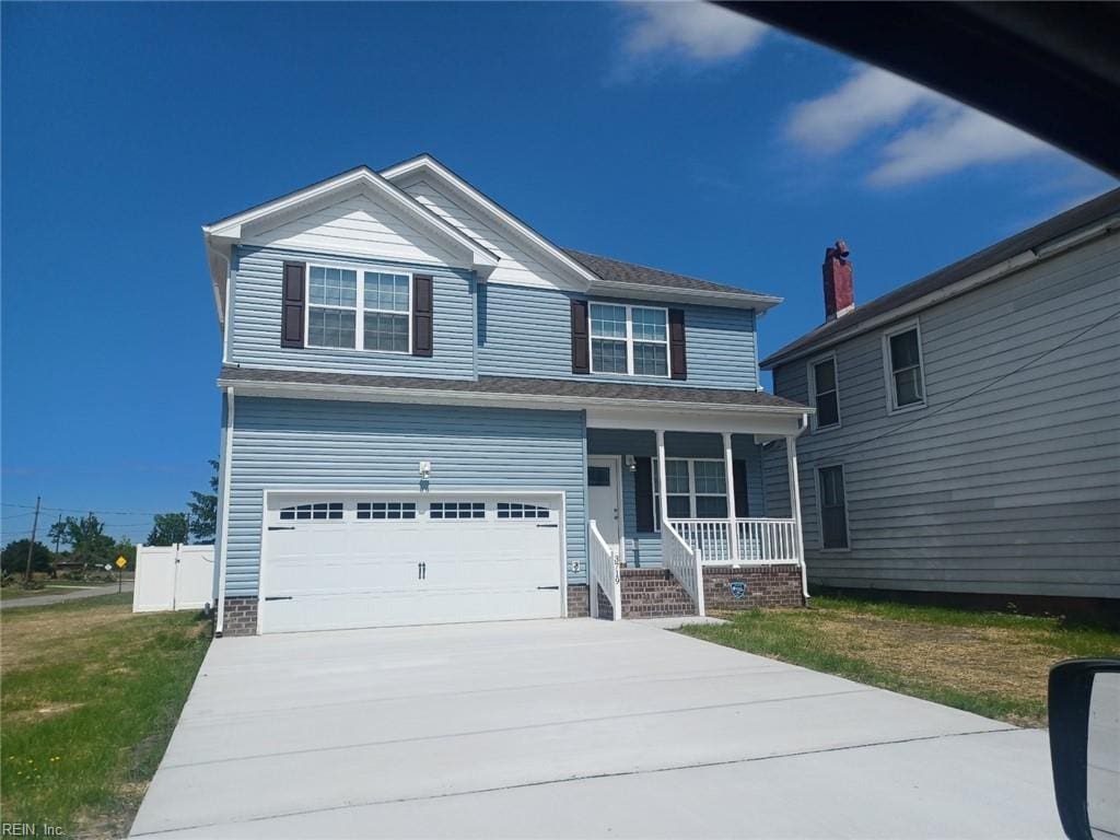 view of front of house featuring a front yard, covered porch, driveway, and an attached garage