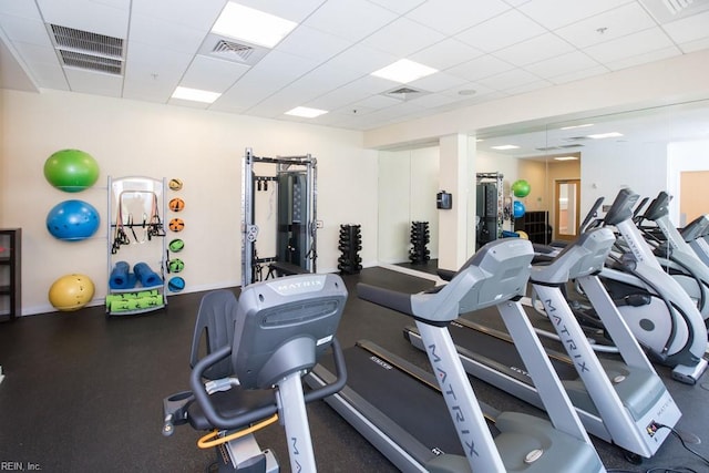 workout area with visible vents and a paneled ceiling