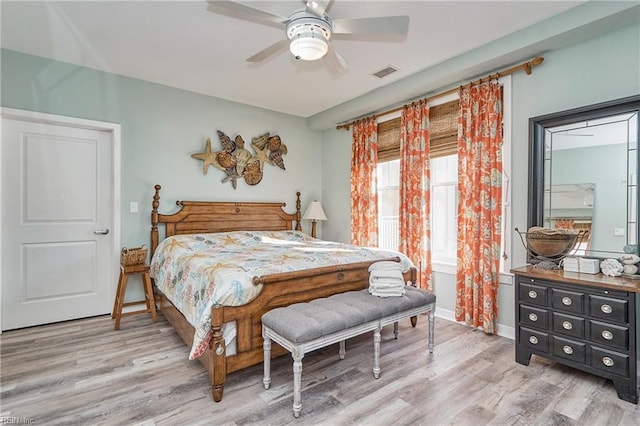 bedroom featuring baseboards, light wood-type flooring, visible vents, and a ceiling fan