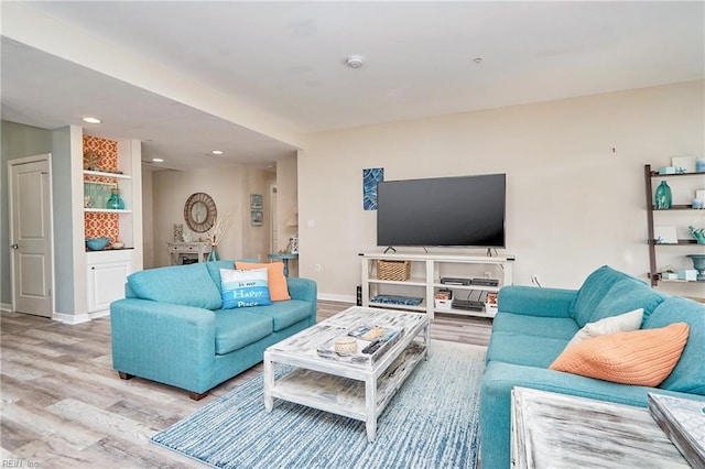 living area with light wood-type flooring, baseboards, and recessed lighting