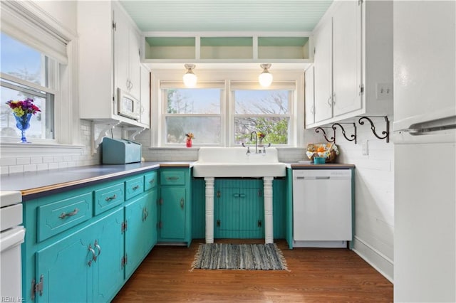 kitchen featuring decorative backsplash, white appliances, dark wood-type flooring, and a sink