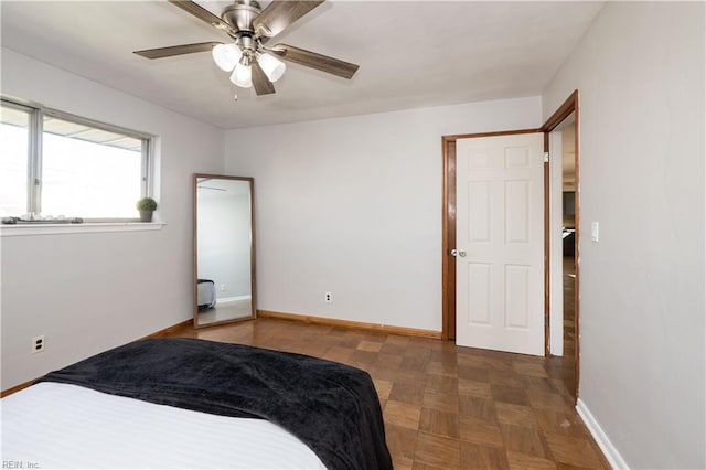 bedroom with ceiling fan and baseboards