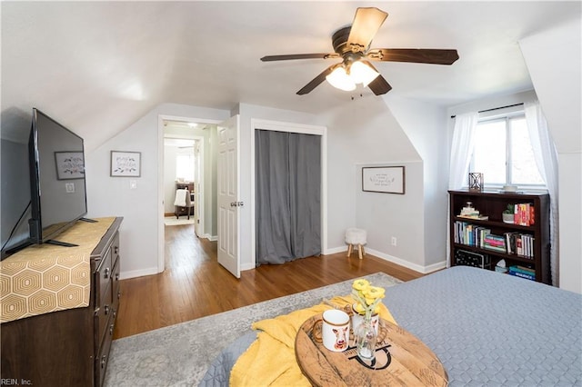 bedroom with lofted ceiling, ceiling fan, wood finished floors, and baseboards