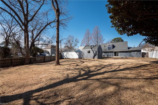 view of yard with an outbuilding, fence, and a storage shed