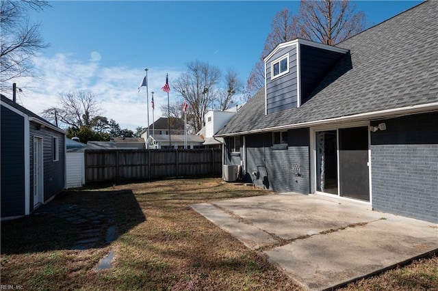 view of yard with a patio area, fence, and central AC