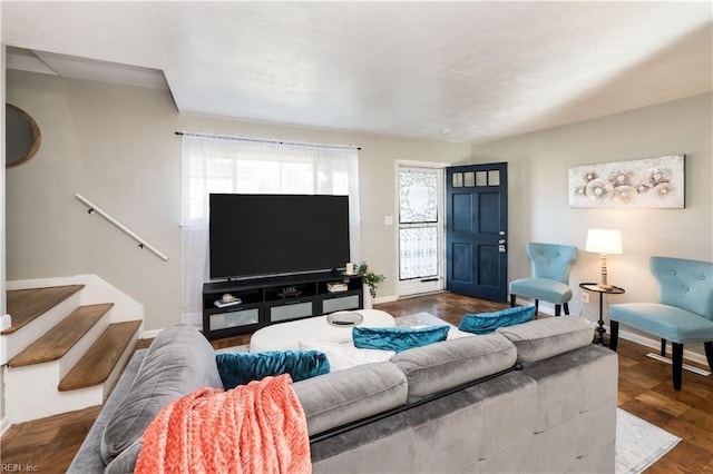 living area featuring wood finished floors, baseboards, and stairs