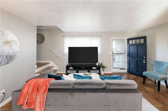 living room featuring baseboards and stairway