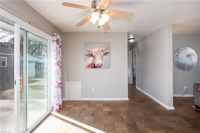 unfurnished room with a ceiling fan and baseboards