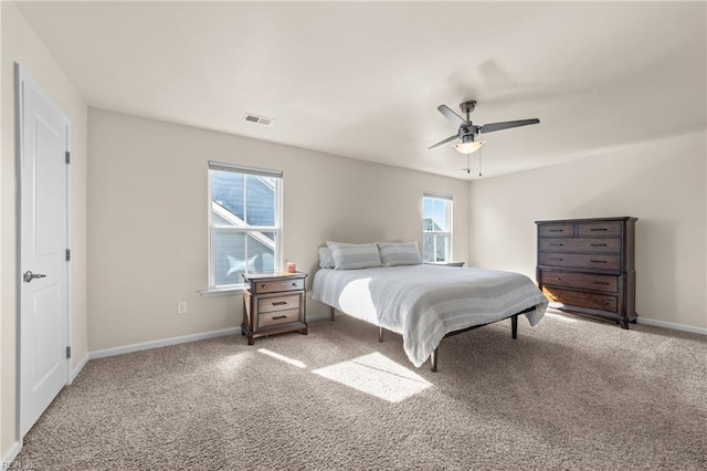 carpeted bedroom featuring baseboards, multiple windows, and visible vents