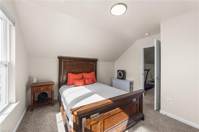 bedroom with multiple windows, vaulted ceiling, and carpet flooring