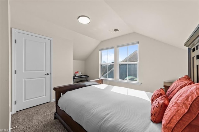 carpeted bedroom with visible vents and vaulted ceiling