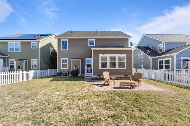 back of house featuring entry steps, a patio, a yard, and a fenced backyard