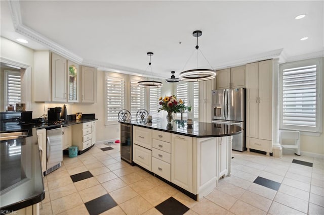 kitchen featuring hanging light fixtures, appliances with stainless steel finishes, glass insert cabinets, and cream cabinetry