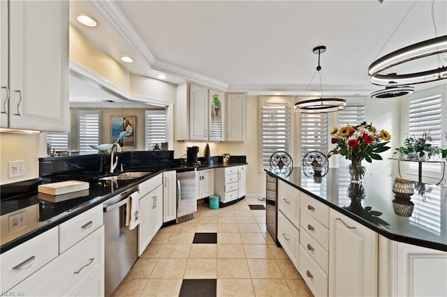 kitchen featuring light tile patterned floors, dark countertops, stainless steel dishwasher, white cabinets, and a sink