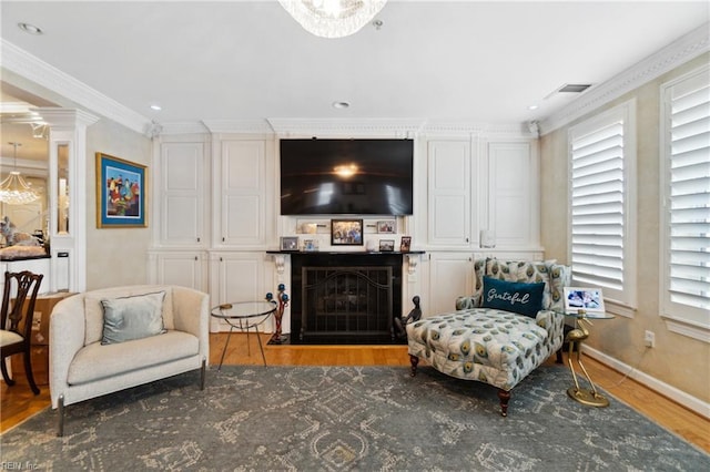 interior space featuring baseboards, visible vents, ornamental molding, wood finished floors, and a fireplace