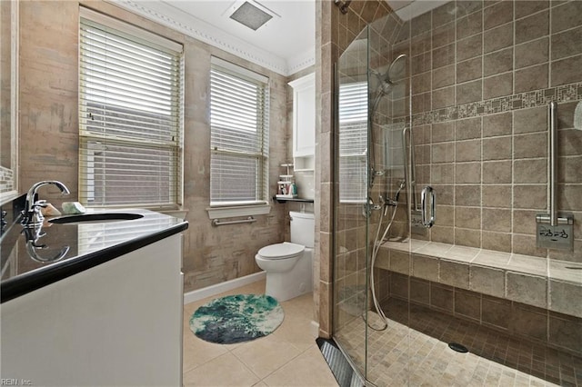 bathroom featuring toilet, a stall shower, vanity, and tile patterned floors