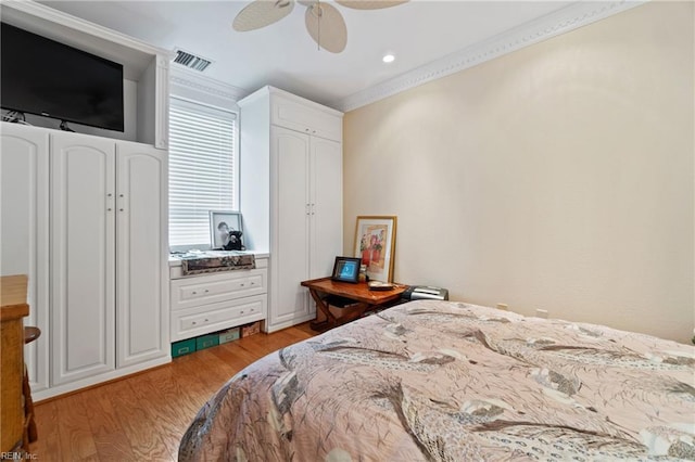 bedroom with a ceiling fan, light wood-type flooring, visible vents, and crown molding