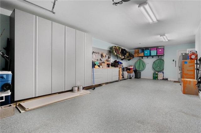 garage featuring freestanding refrigerator and baseboards