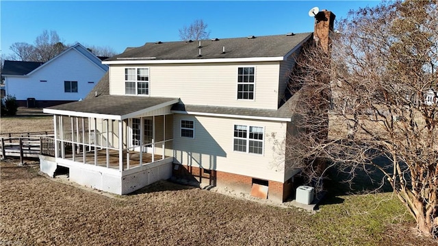 rear view of property with crawl space, a sunroom, and a yard