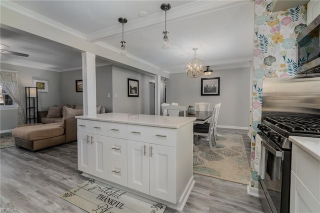 kitchen with light wood-style flooring, white cabinetry, light countertops, ornamental molding, and appliances with stainless steel finishes