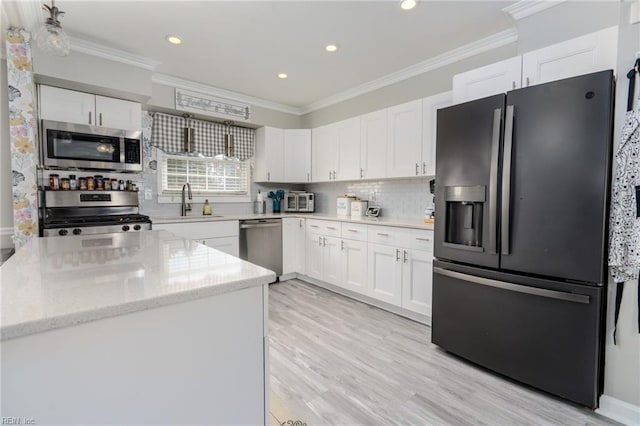 kitchen with appliances with stainless steel finishes, white cabinetry, crown molding, and decorative backsplash