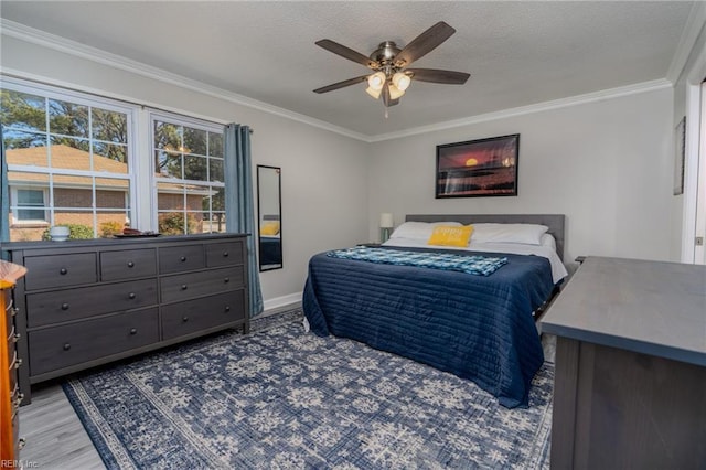 bedroom with a textured ceiling, wood finished floors, a ceiling fan, and crown molding