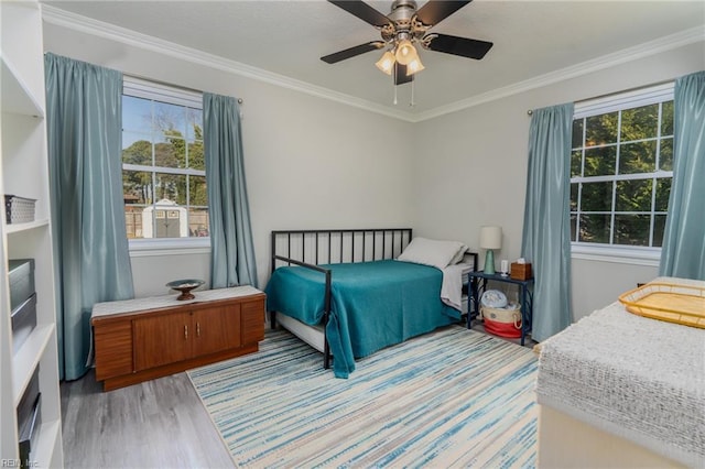 bedroom with crown molding, a ceiling fan, and light wood-style floors