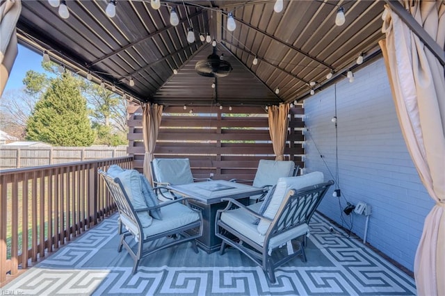 view of patio with a gazebo, fence, and outdoor dining space