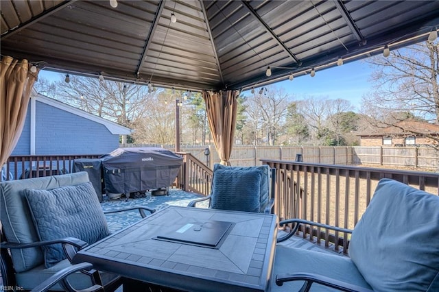 deck featuring a gazebo, area for grilling, a fenced backyard, and outdoor dining space