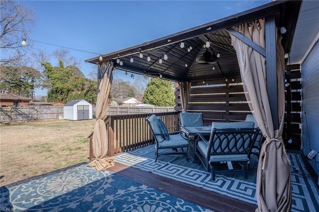 wooden terrace with an outbuilding, a yard, a storage unit, and a fenced backyard