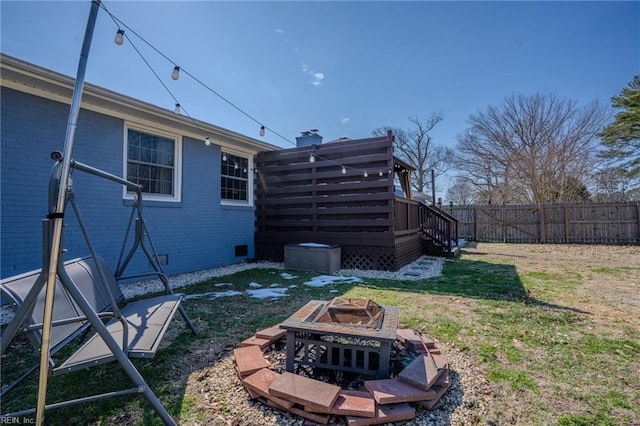 view of yard with fence, a fire pit, and a wooden deck