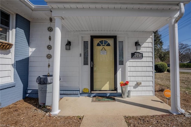 view of exterior entry featuring covered porch