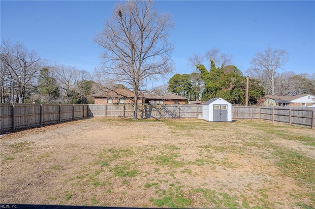 view of yard with a fenced backyard, an outdoor structure, and a storage unit