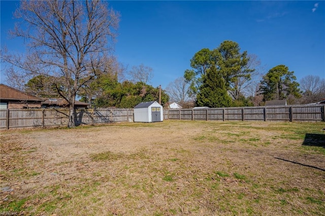 view of yard featuring an outbuilding, a shed, and a fenced backyard