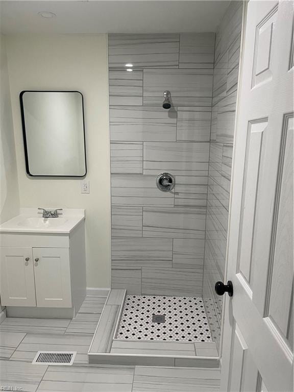 bathroom with a stall shower, visible vents, and vanity