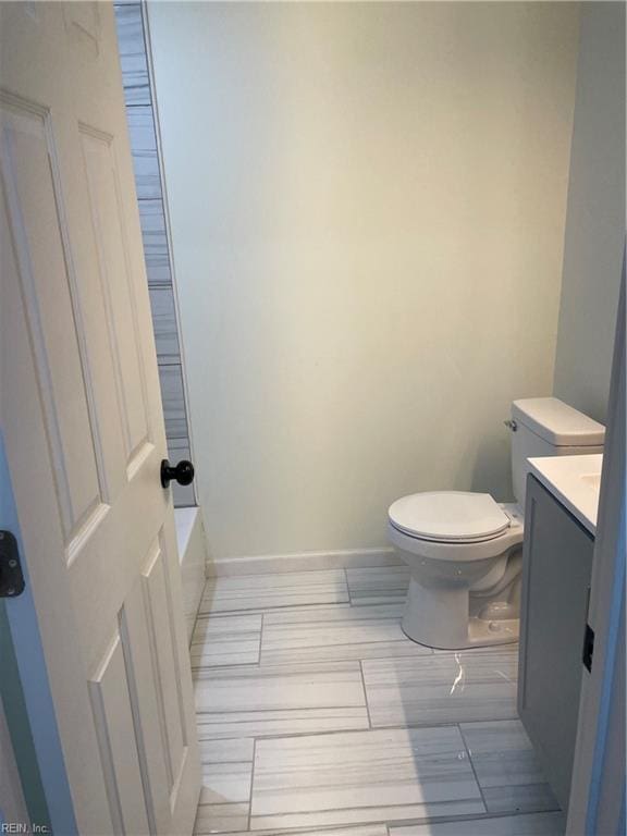 full bathroom featuring baseboards, vanity, and toilet