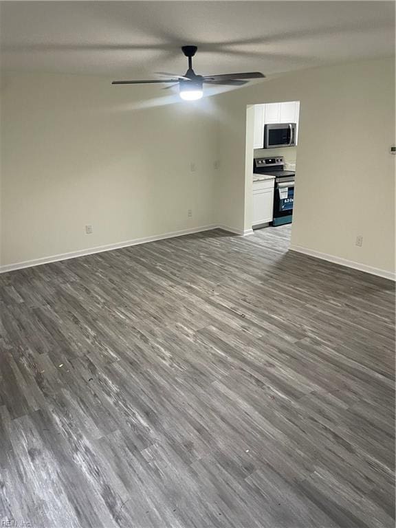 empty room featuring dark wood-style floors, ceiling fan, and baseboards