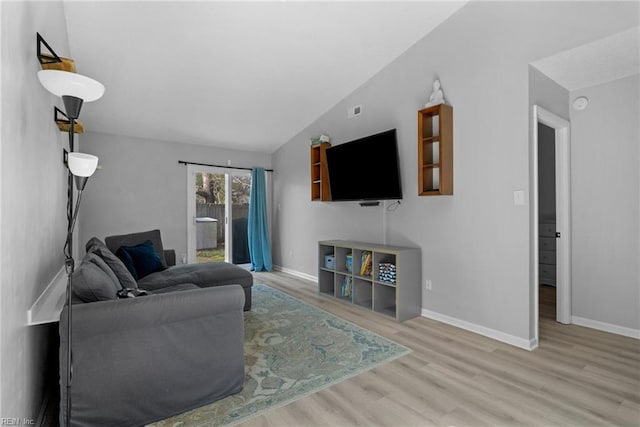 living room with baseboards, vaulted ceiling, and wood finished floors