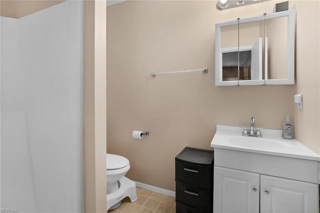 bathroom with toilet, baseboards, and vanity