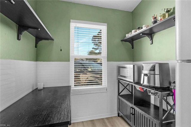 interior space featuring a wainscoted wall and light wood-style floors