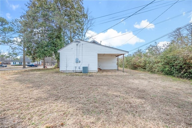 exterior space featuring central air condition unit, driveway, a carport, and a yard