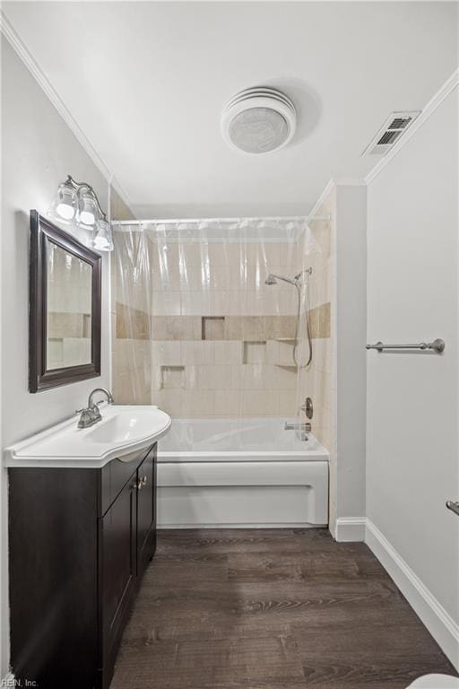 full bath featuring bathtub / shower combination, visible vents, crown molding, and wood finished floors