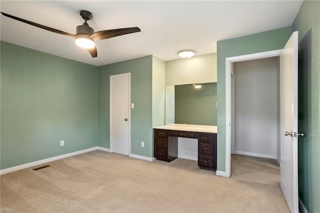 unfurnished bedroom with light carpet, a ceiling fan, visible vents, and baseboards