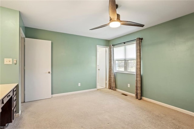 unfurnished bedroom featuring a ceiling fan, light colored carpet, visible vents, and baseboards