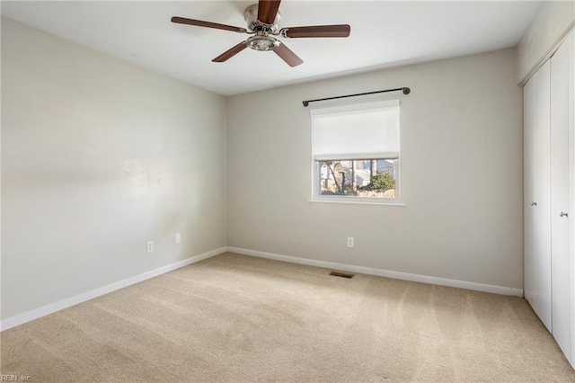 unfurnished room with light carpet, ceiling fan, visible vents, and baseboards