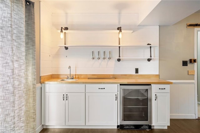 bar with dark wood-style floors, wine cooler, indoor wet bar, and a sink