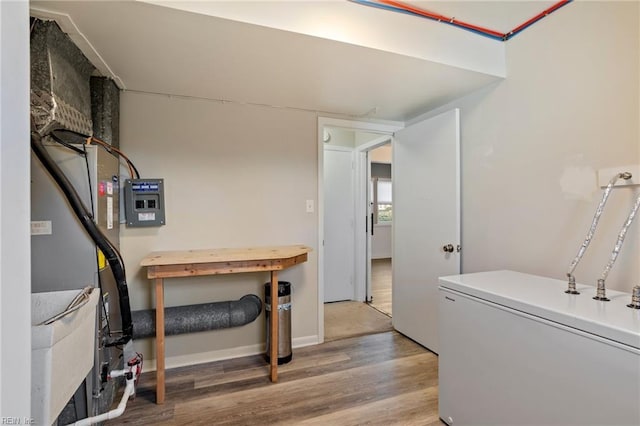 laundry area with baseboards and wood finished floors