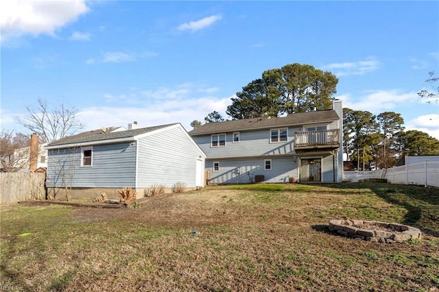 rear view of house with a lawn, fence, a fire pit, and stairs